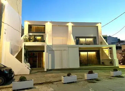 a white house with a car parked in front of it at mare suites 4 in Chania Town
