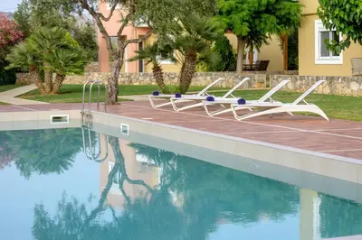 a swimming pool with two lounge chairs next to a house at Aloni Grove Retreat in Chania Town