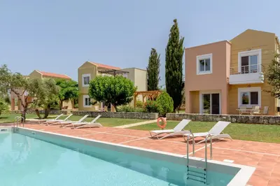 a villa with a swimming pool and a house at Aloni Grove Retreat in Chania Town