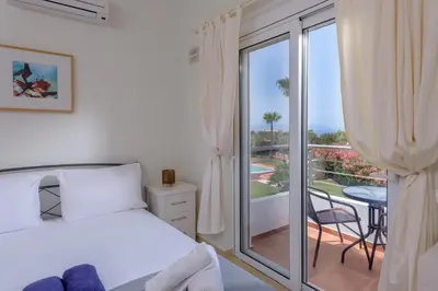 a bedroom with a bed and a balcony at Aloni Grove Retreat in Chania Town