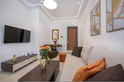 a living room with a couch and a tv at Cherry Central Luxury Suites in Chania Town