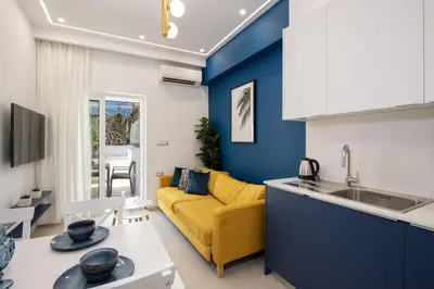 a kitchen and living room with a yellow couch at Cherry Central Luxury Suites in Chania Town