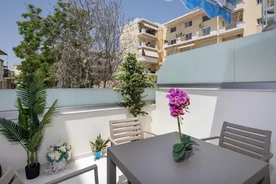 a table and chairs on a balcony with plants at Cherry Central Luxury Suites in Chania Town