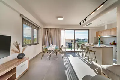a kitchen and living room with a table and chairs at Thearia villa II private heated hydromassage pool in Souda