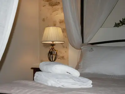 a pile of towels on a bed next to a lamp at Christina's Villa with sea view in Daratso