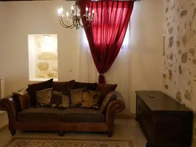 a living room with a couch and a red curtain at Christina's Villa with sea view in Daratso
