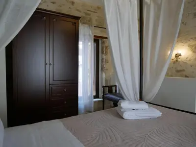 a bedroom with a bed with white towels on it at Christina's Villa with sea view in Daratso