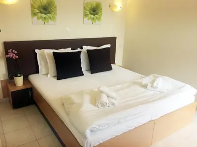 a large white bed with two slippers on it at Posto studio 3 Chania Crete 100m from the beach in Daratso