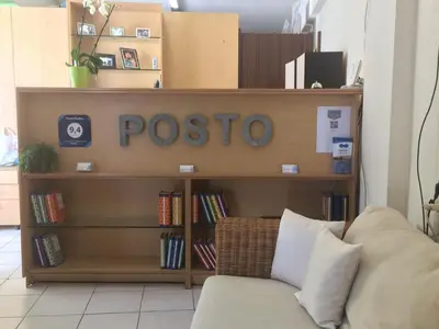a book shelf with the word poseo on it next to a couch at Posto studio 3 Chania Crete 100m from the beach in Daratso