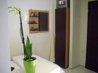 a green vase with white flowers sitting on a table at Posto Studio 5 Chania Crete 100 m from the beach in Daratso
