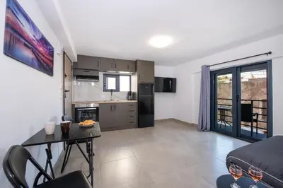 a kitchen and living room with a table and chairs at Halepa Apartment's in Chania in Chania Town