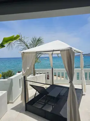 a white canopy on a patio with the ocean at Beachfront luxury suite in Kalyves