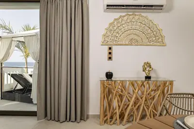 a living room with a curtain and a table at Beachfront luxury suite in Kalyves