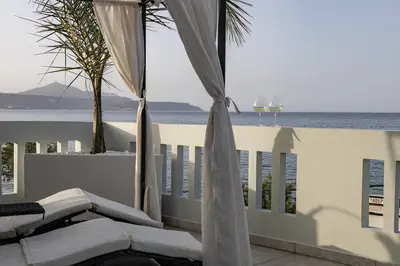 a white balcony with a view of the ocean at Beachfront luxury suite in Kalyves