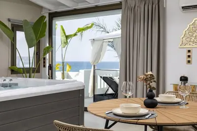 a dining room with a table and a view of the ocean at Beachfront luxury suite in Kalyves