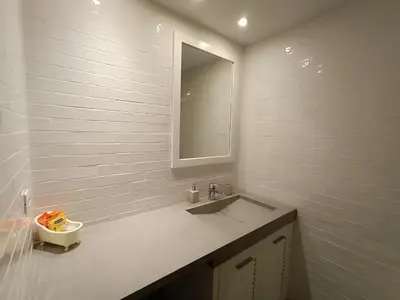 a white bathroom with a sink and a mirror at Sandy Suite 1 in Agia Marina Nea Kydonias