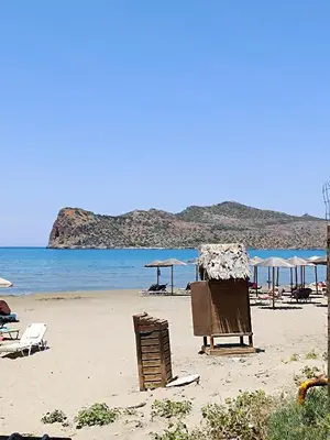 a beach with chairs and umbrellas and the ocean at Sandy Suite 1 in Agia Marina Nea Kydonias