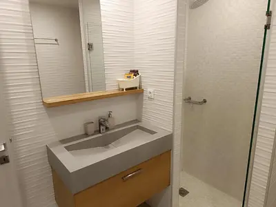 a bathroom with a sink and a mirror and a shower at Sandy Suite 2 in Agia Marina Nea Kydonias