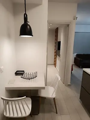 a kitchen with a white table and a white chair at Sandy Suite 3 in Agia Marina Nea Kydonias