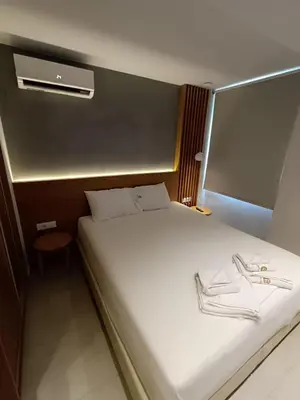 a bedroom with a large bed with a white bedvisor at Sandy Suite 3 in Agia Marina Nea Kydonias