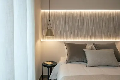 a bedroom with a bed and a pendant light at Sea Path I Chania City Center luxury Suites in Chania Town