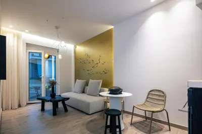 a living room with a couch and a table and chairs at Sea Path II Chania city Center luxury Suites in Chania Town
