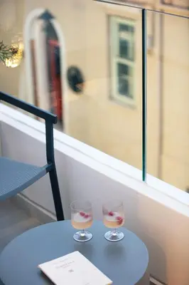 two wine glasses sitting on a table in front of a window at Sea Path II Chania city Center luxury Suites in Chania Town