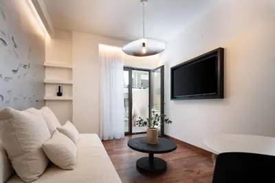 a living room with a couch and a tv at Sea Path III Chania city Center luxury Suites in Chania Town