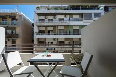 a table and chairs on a balcony with a building at Sea Path III Chania city Center luxury Suites in Chania Town