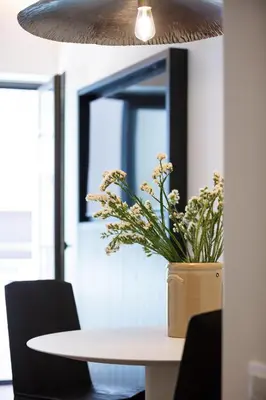 a table with a vase of flowers on top of it at Sea Path III Chania city Center luxury Suites in Chania Town