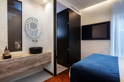 a bedroom with a bed and a sink and a mirror at Sea Path IV Chania city center luxury Appartment in Chania Town