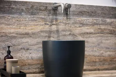 a bathroom sink with a faucet and a black bucket at Sea Path IV Chania city center luxury Appartment in Chania Town