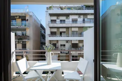 a table and chairs on a balcony with a view of a building at Sea Path IV Chania city center luxury Appartment in Chania Town