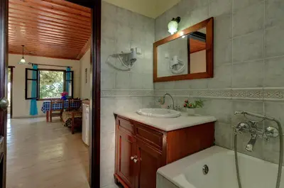 a bathroom with a sink and a tub and a mirror at Heliopetra studios, small village near beaches in Douliana