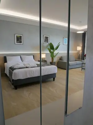 a bedroom with a bed and a large mirror at Amour Relax Hotel in Almirida