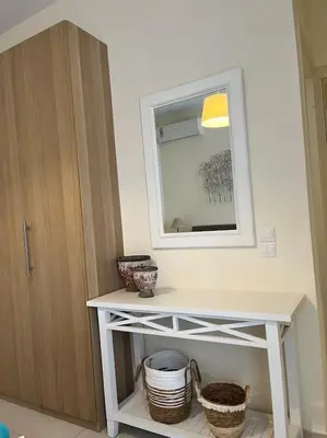 a bathroom with a mirror and a table with baskets at Colibri seafront villa with pool in Nopíyia