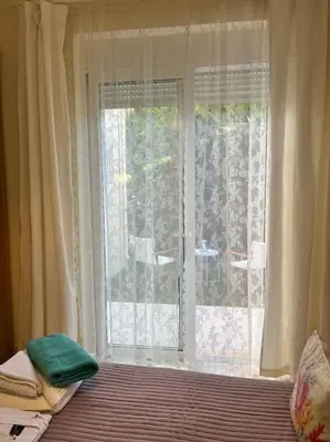 a room with a window and a bed and a window with curtains at Colibri seafront villa with pool in Nopíyia