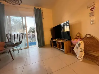a living room with a flat screen tv and a couch at Colibri seafront villa with pool in Nopíyia