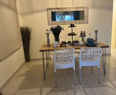 a dining room table with two chairs and a mirror at Colibri seafront villa with pool in Nopíyia
