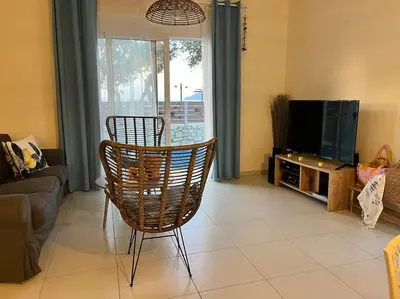 a living room with a chair and a television at Colibri seafront villa with pool in Nopíyia