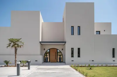 a building with a palm tree in front of it at Nemia Luxury Residence in Chania Town