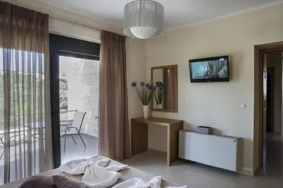 a bedroom with a bed and a tv on the wall at Villa-Azalea in Almirida