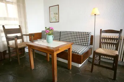 a living room with a couch and a table and chairs at Proimos Maisonnettes in Plataniás