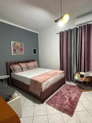 a bedroom with a large bed and purple curtains at Marias Apartment in Chania Town