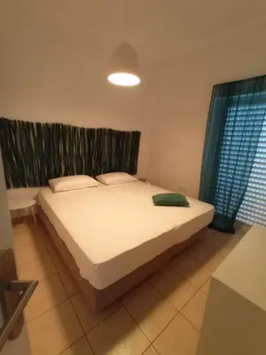 a bedroom with a large white bed with a window at Sonema Seaside Apt in Chania Town