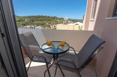 a glass table and two chairs on a balcony at Filitsa's Luxury House in Chania Town