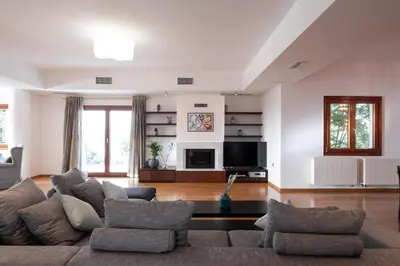 a living room with a couch and a tv at Fleur du sud - Villa in Chania in Korakiaí