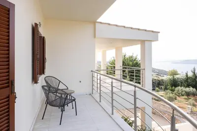 a balcony with two chairs and a view of the ocean at Fleur du sud - Villa in Chania in Korakiaí