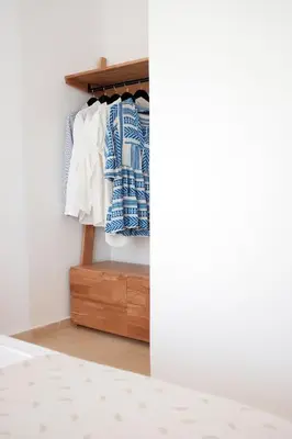a bedroom with white walls and a closet with clothes at Everlane Seaview Villa in Arménoi