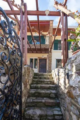 a stone stairway leading to a house with a gate at Jacuzzi Villa Nena in Thérison